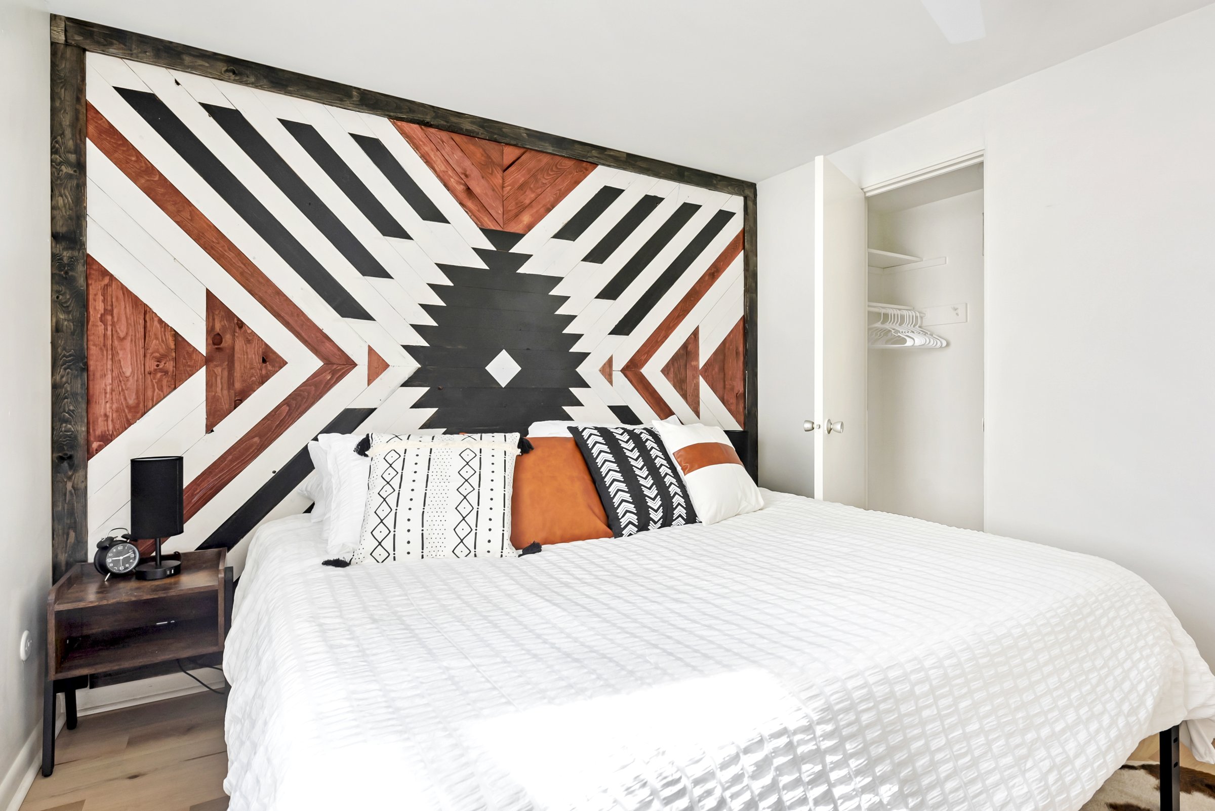 Finished bedroom with a geometric wood feature wall