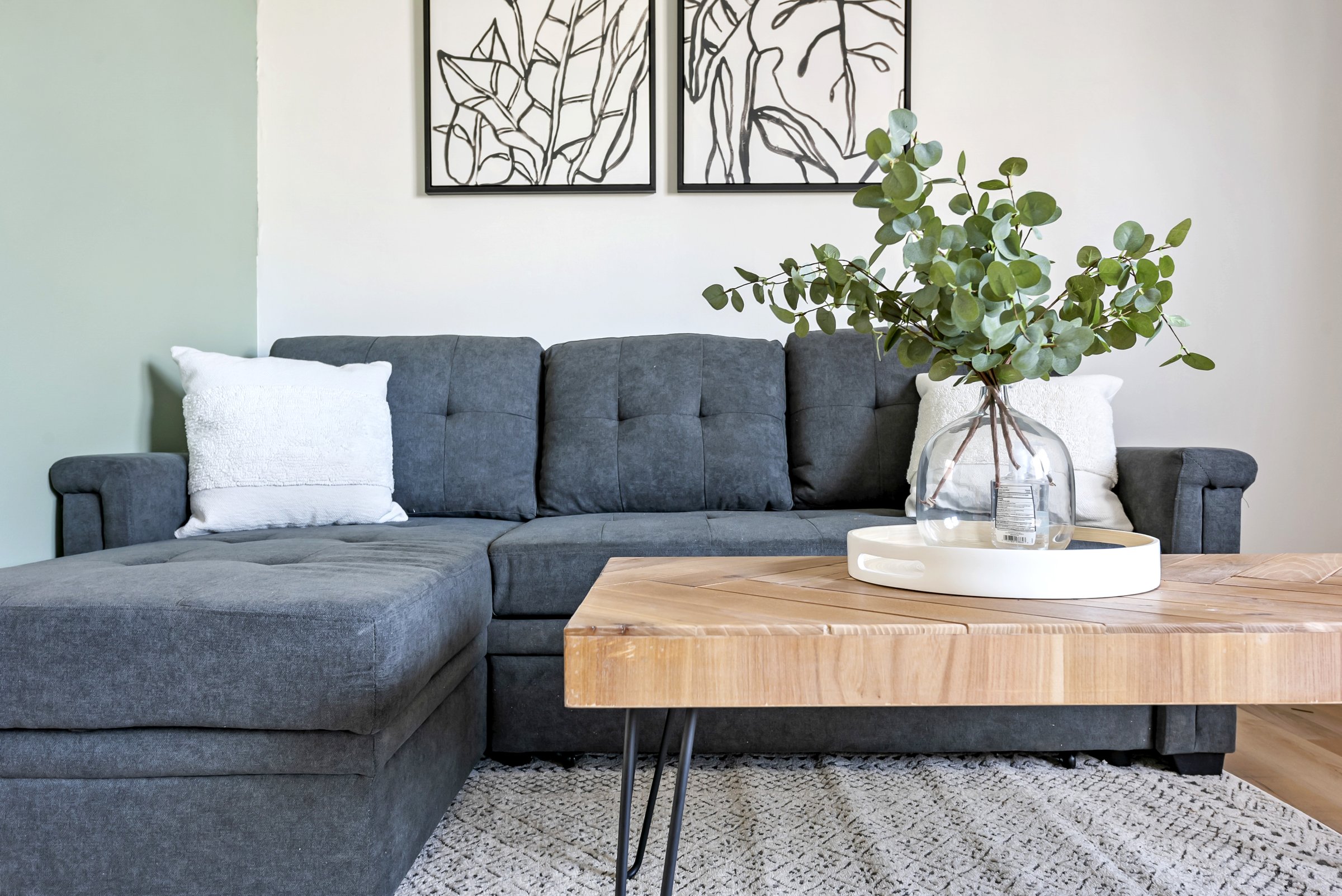 Living room with a charcoal sofa and natural wood table